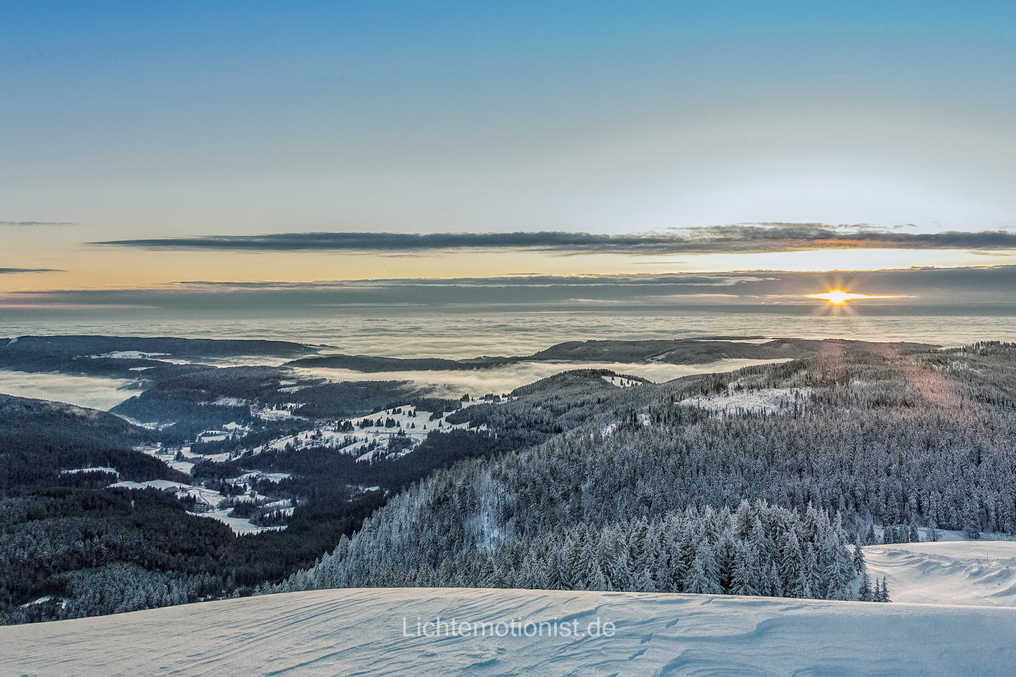 Winterliche Bergsicht auf verschneiten Wald und Nebeltäler