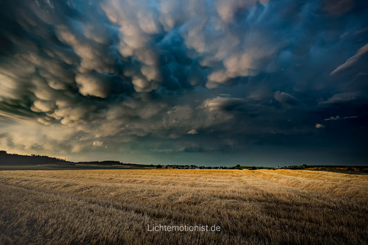 Düstere Weite: Dunkle Wolken über einem weiten Feld